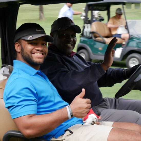Golfers at 29th annual Gabriel Homes golf tournament riding in golf cart.
