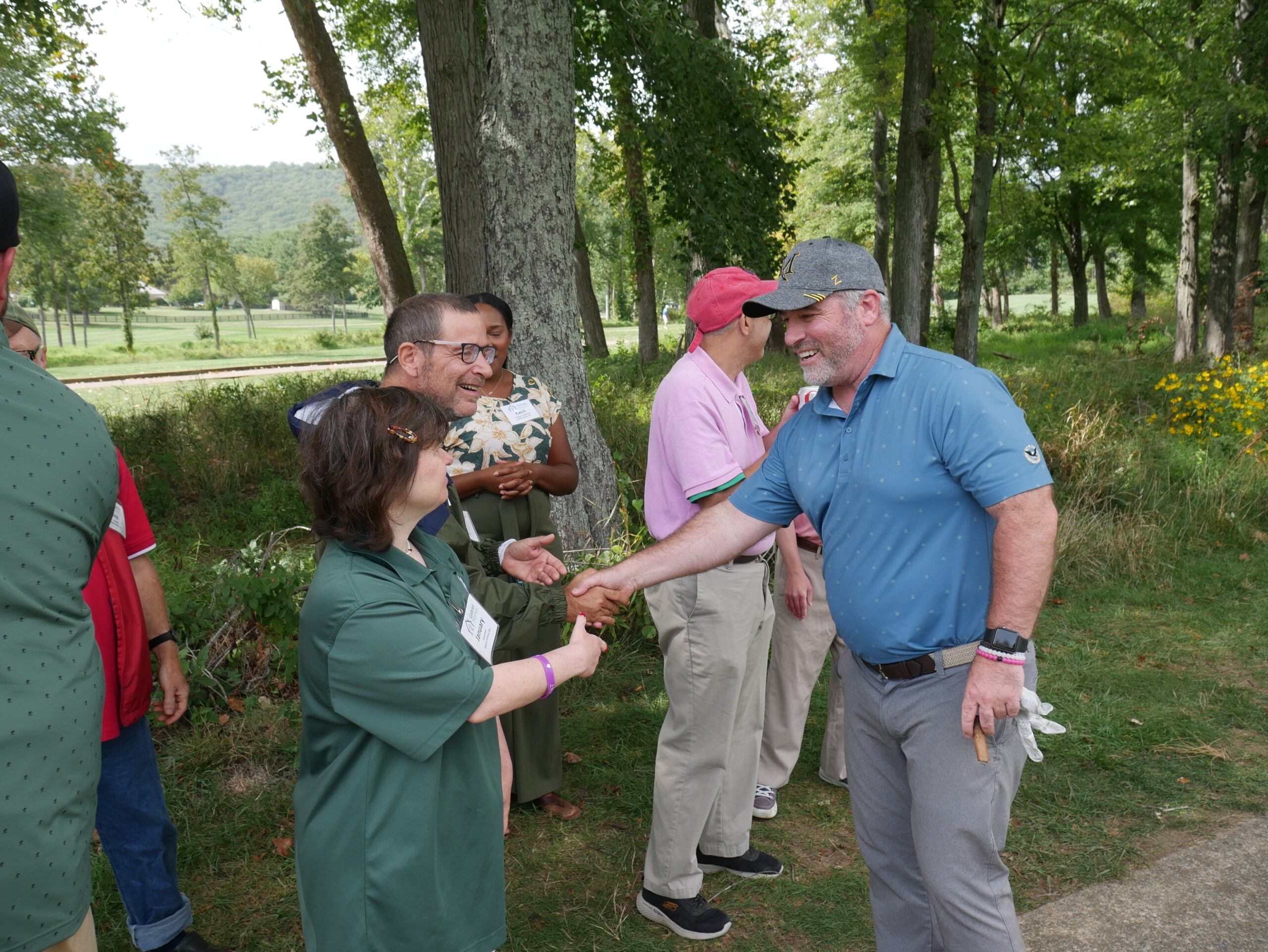 Gabriel Homes resident (left) shaking hands with a golfer (right).
