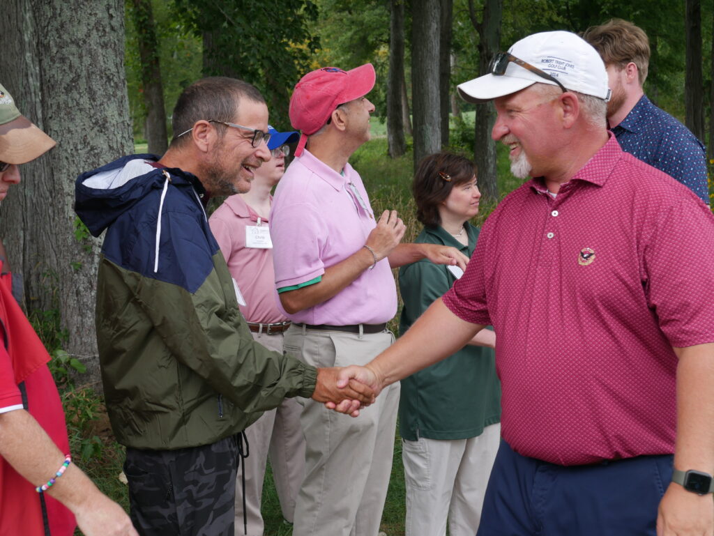Gabriel Homes resident (left) shaking hands with a participant at the 29th annual Gabriel Homes golf tournament.