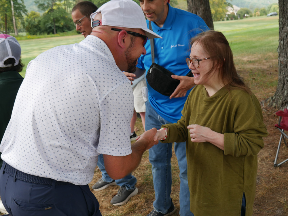 Gabriel Homes resident (right) shaking hands with a golfer (left) from the 30th Annual Golf Tournament.