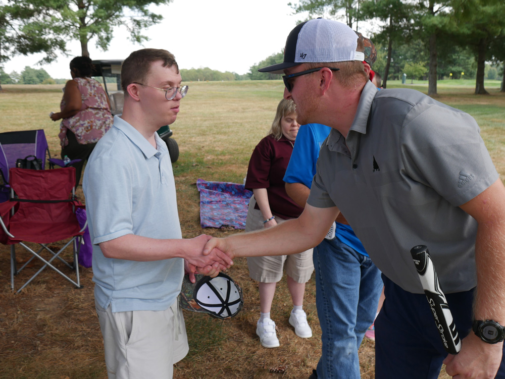 Gabriel Homes resident (left) and golfer (right) shaking hands at the 30th Annual Golf Tournament.
