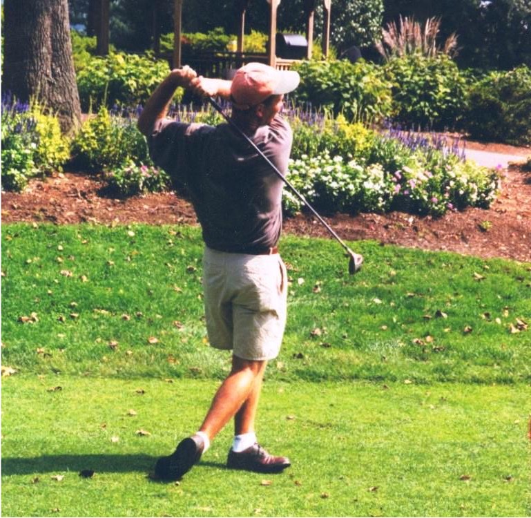 Golfer swinging club at the Gabriel Homes Golf Tournament.