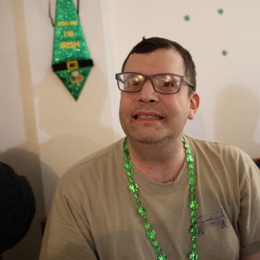 Gabriel Homes resident with St. Patrick's Day decor in the background.