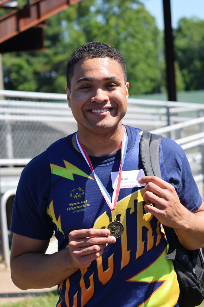 Special Olympics athlete holding their medal.