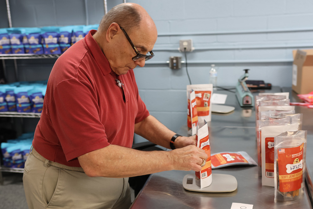 Gabriel Homes resident weighing a bag of dog treats.