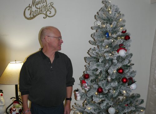 Gabriel Homes resident standing next to a Christmas tree.