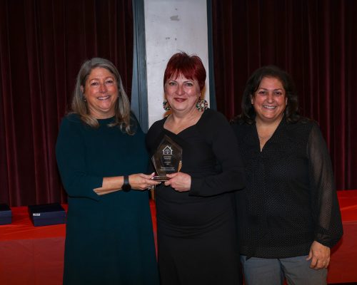 Left to right: Gabriel Homes Executive Director, Hall of Fame class of 2025 John H.'s sister Liesl, and Board Chair Michele Bolos.