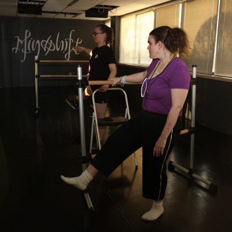 Dancers doing leg lifts.