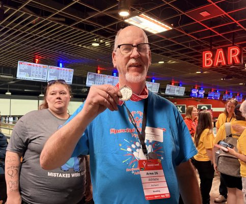 Gabriel Homes resident holding Special Olympics bowling silver medal from state games.