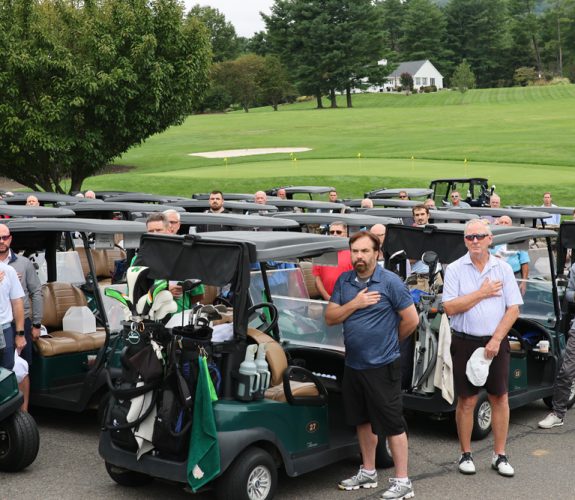 Golfers with hands over their hearts at the Gabriel Homes Golf Tournament.
