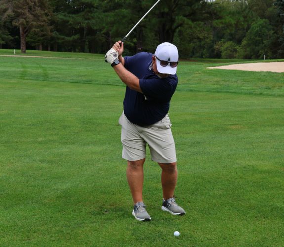 Golfer swinging club.