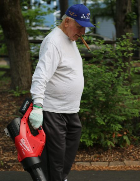 Mike Holupka, former chair of the Gabriel Homes board of directors, using a leaf blower for the Gabriel Homes Work Crew.