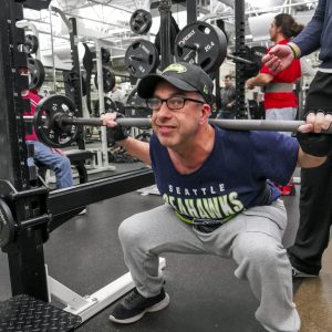 Gabriel Homes resident powerlifting wearing Seattle Seahawks gear.