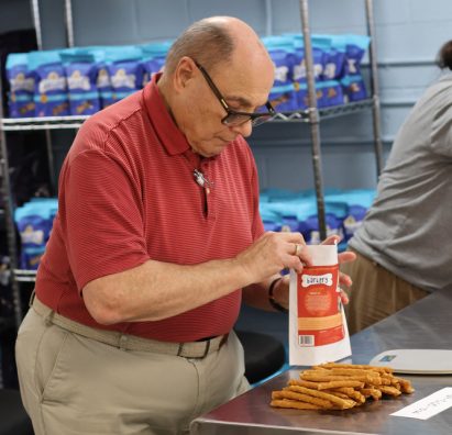 Gabriel Homes resident filling a bag of dog treats at work.