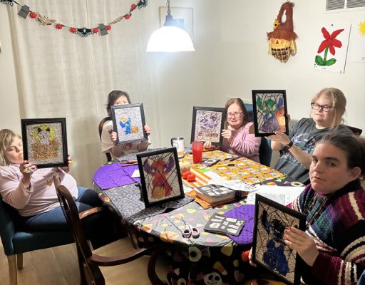 Gabriel Homes residents holding up their stained glass art projects.