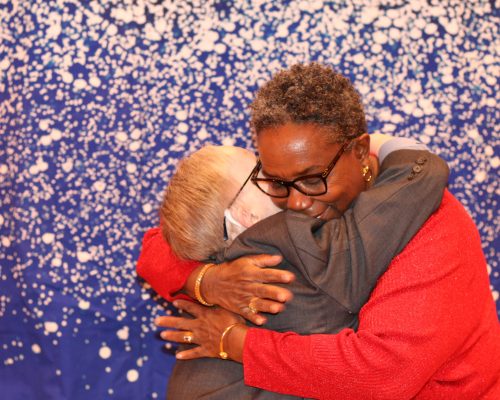 Esther Eastman Greene (right) hugging a Gabriel Homes resident (left).