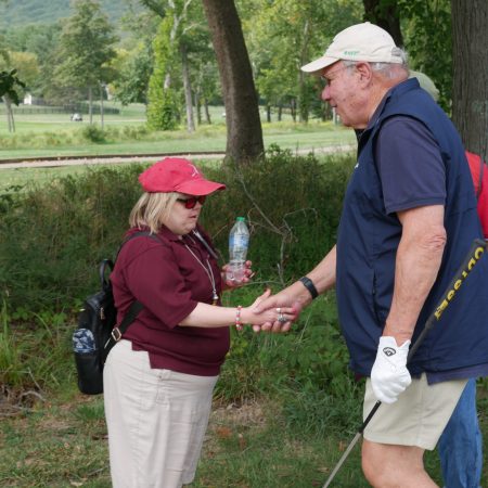 Monsignor Bob Cilinski (right), a faith leader in Northern Virginia, at the Gabriel Homes Golf Tournament meeting a resident (left).