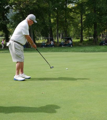 Golfer putting at the Gabriel Homes golf tournament.