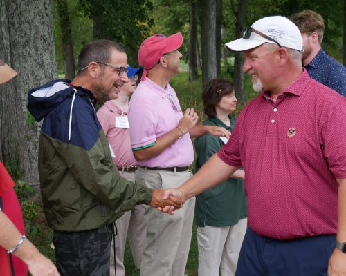 Gabriel Homes resident (left) shaking hands with a participant at the 29th annual Gabriel Homes golf tournament.