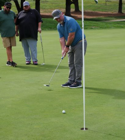 Golfer putting at the Gabriel Homes golf tournament.