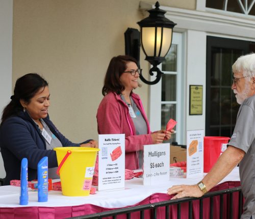 Shalini Kapur (left), director of the development committee on the board of directors, distributing tickets at the 29th Annual Gabriel Homes Golf Tournament.
