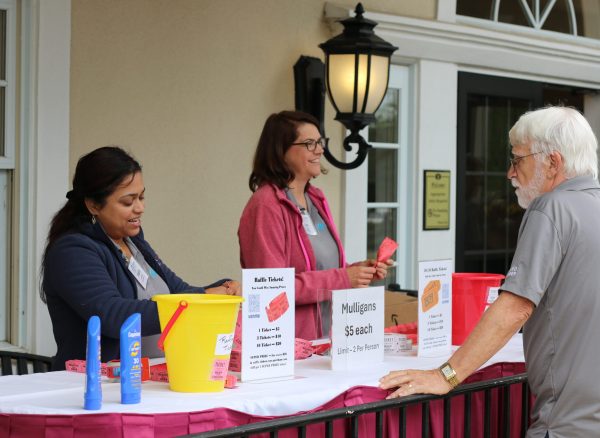 Shalini Kapur (left), director of the development committee on the board of directors, distributing tickets at the 29th Annual Gabriel Homes Golf Tournament.