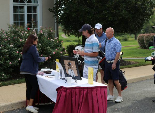Shalini Kapur (left), director of the development committee on the board of directors, checking guests in to the 29th Annual Gabriel Homes Golf Tournament.