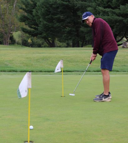 Golfer putting at the Gabriel Homes golf tournament.