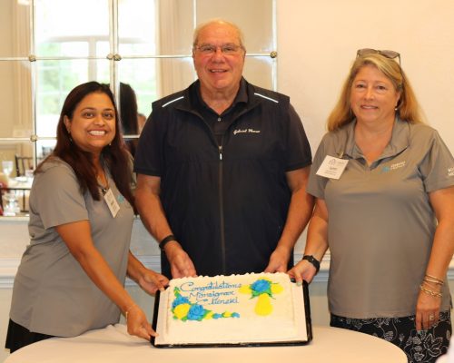 Monsignor Bob Cilinski (center) with cake at Gabriel Homes Golf Tournament.