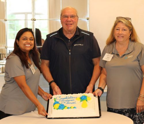 Monsignor Bob Cilinski (center) with cake at Gabriel Homes Golf Tournament.