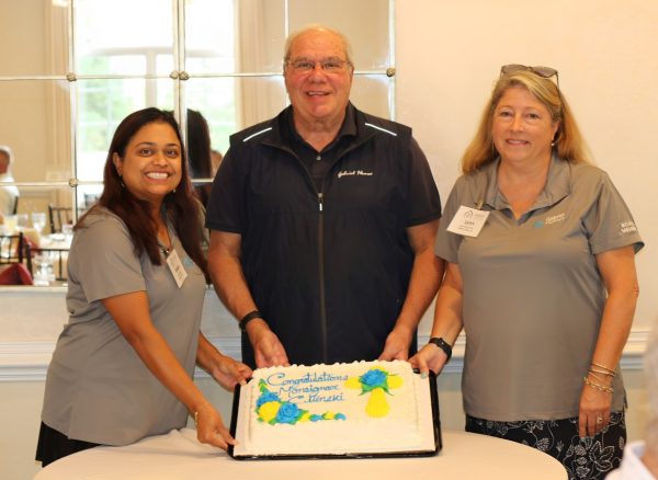 Monsignor Bob Cilinski (center) with cake at Gabriel Homes Golf Tournament.