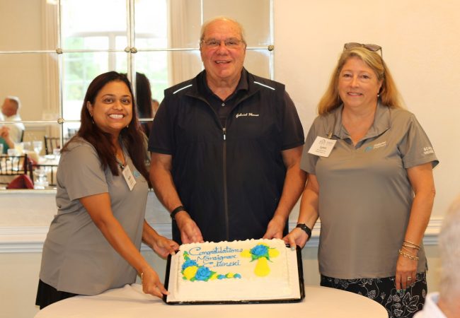 Monsignor Bob Cilinski (center) with cake at Gabriel Homes Golf Tournament.