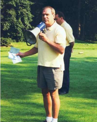 Then-Father Bob Cilinski speaking using a megaphone at the Gabriel Homes Golf Tournament.