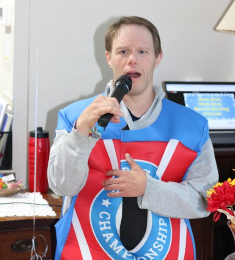 Gabriel Homes resident at the Boo Bash singing karaoke, celebrating Christmas.