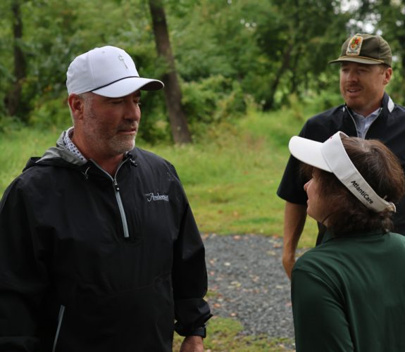 Golfer (left) chatting with Gabriel Homes resident (right).