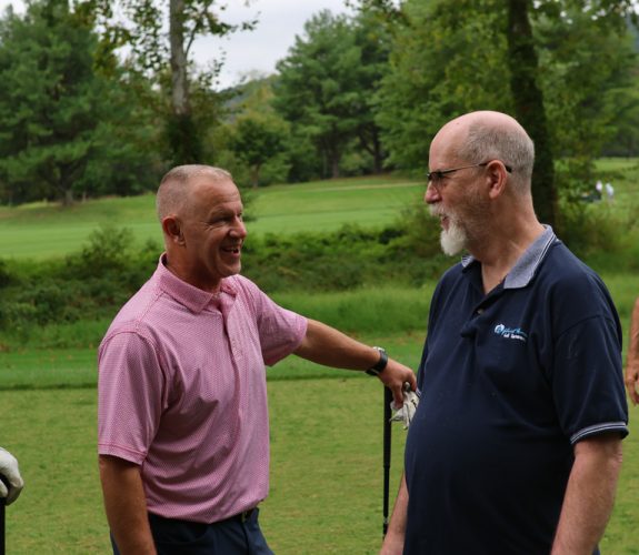Gabriel Homes resident (right) chatting with a golfer (left).