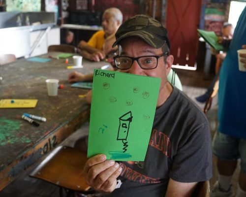 Gabriel Homes resident holding up a drawing made at Camp Jaycee.