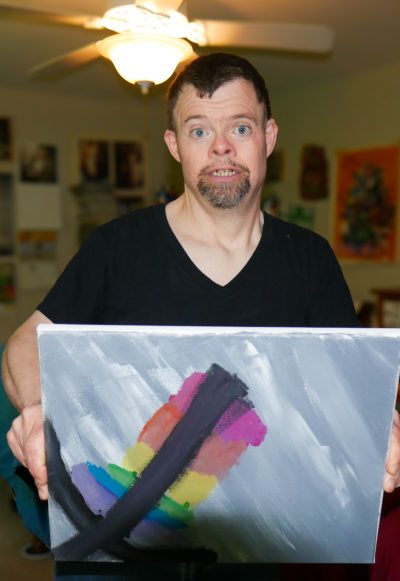Gabriel Homes resident holding a canvas they painted.