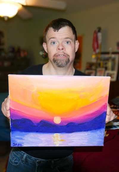 Gabriel Homes resident holding a canvas they painted.