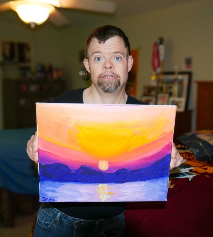 Gabriel Homes resident holding a canvas they painted.